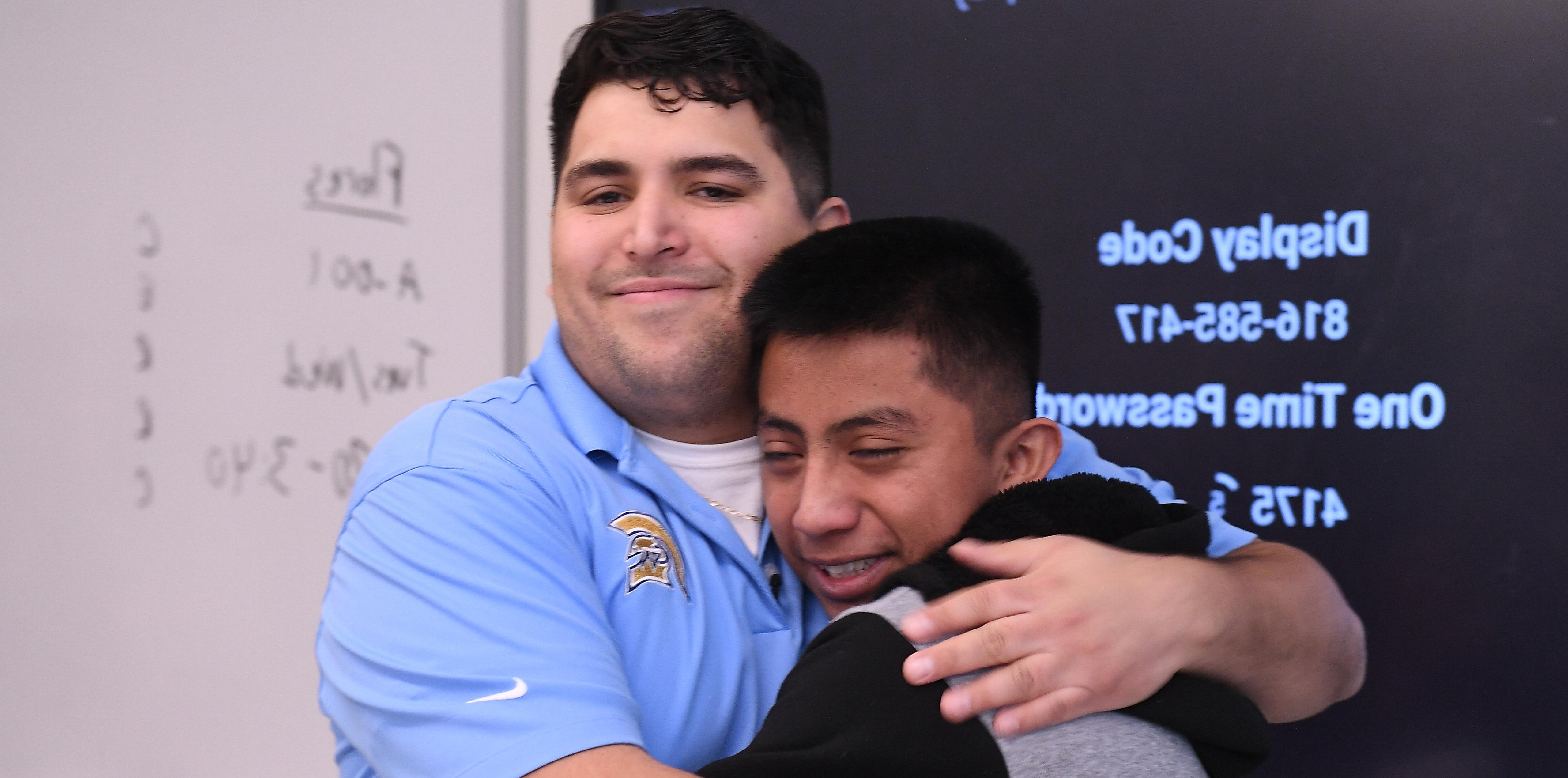 Caleb Flores hugging one of his male students